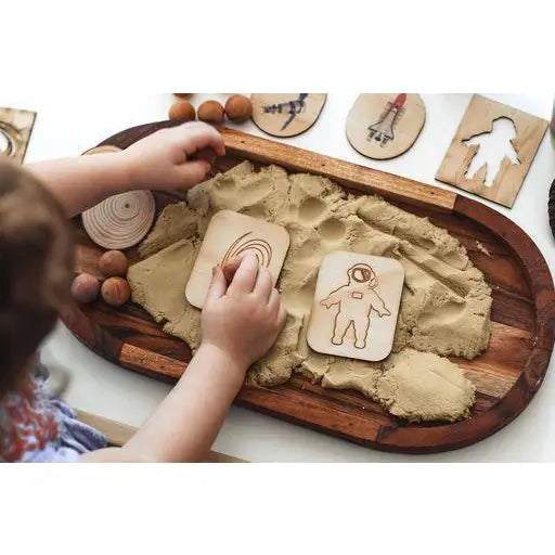 Wooden tray filled with sand or clay for children’s sensory play and shape-making activities.
