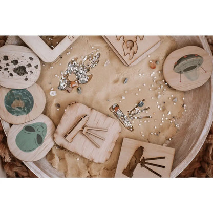 Wooden tray displaying various ceramic or clay craft items and decorative elements.