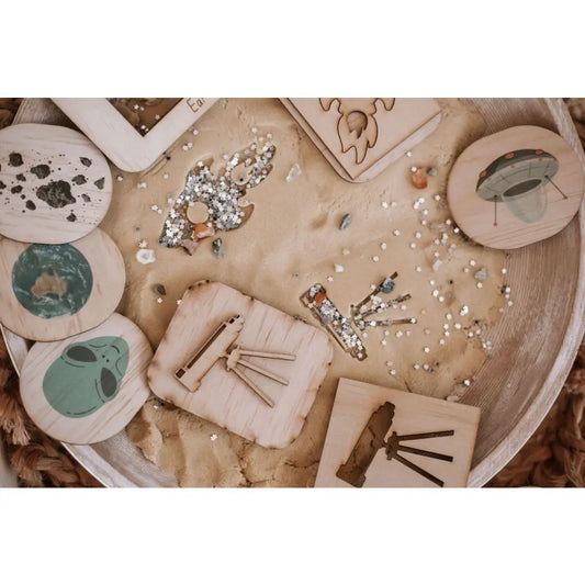 Wooden tray displaying various ceramic or clay craft items and decorative elements.