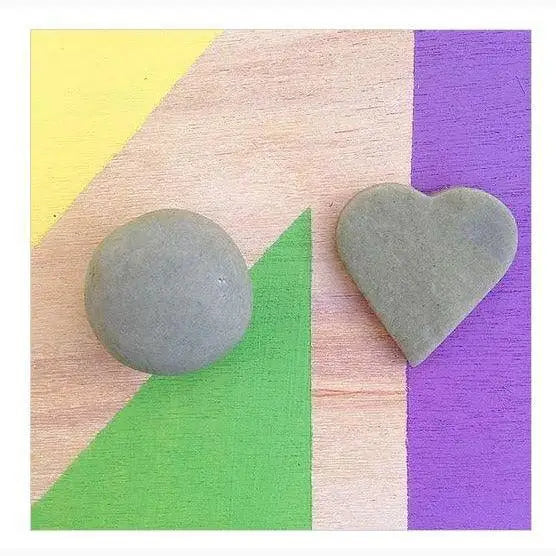 Two smooth gray stones, one round and one heart-shaped.