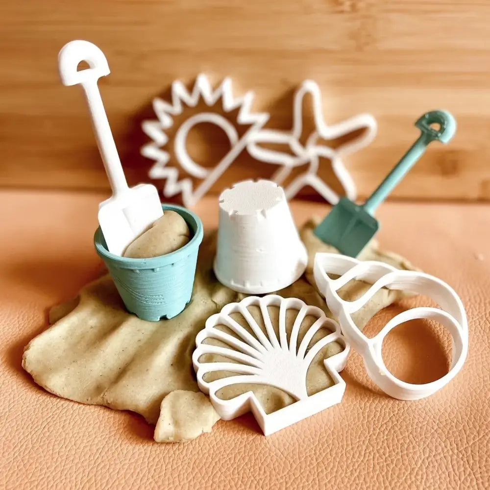 Collection of beach-themed miniature toys and molds for sand play.