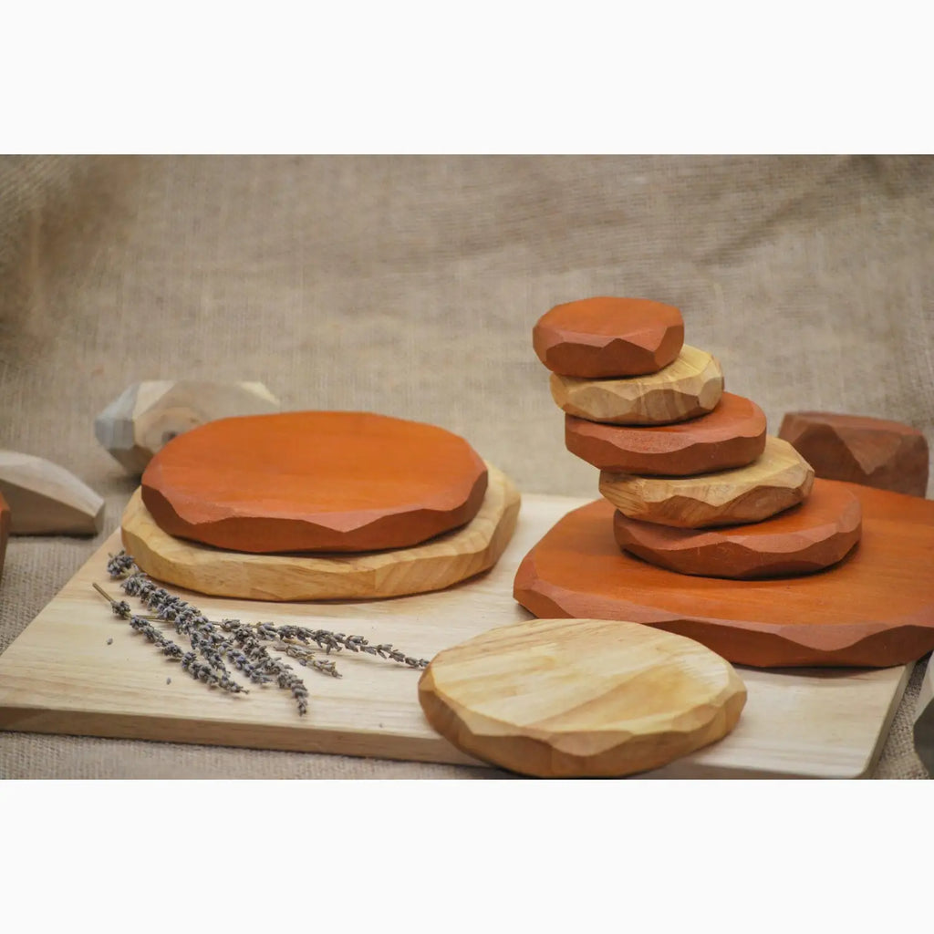 Clay pottery pieces in various shapes and sizes arranged on a wooden board.