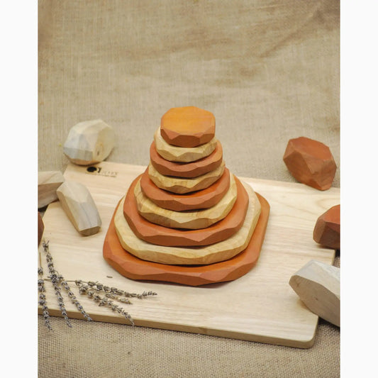 Stacked wooden discs forming a pyramid-like shape on a cutting board.