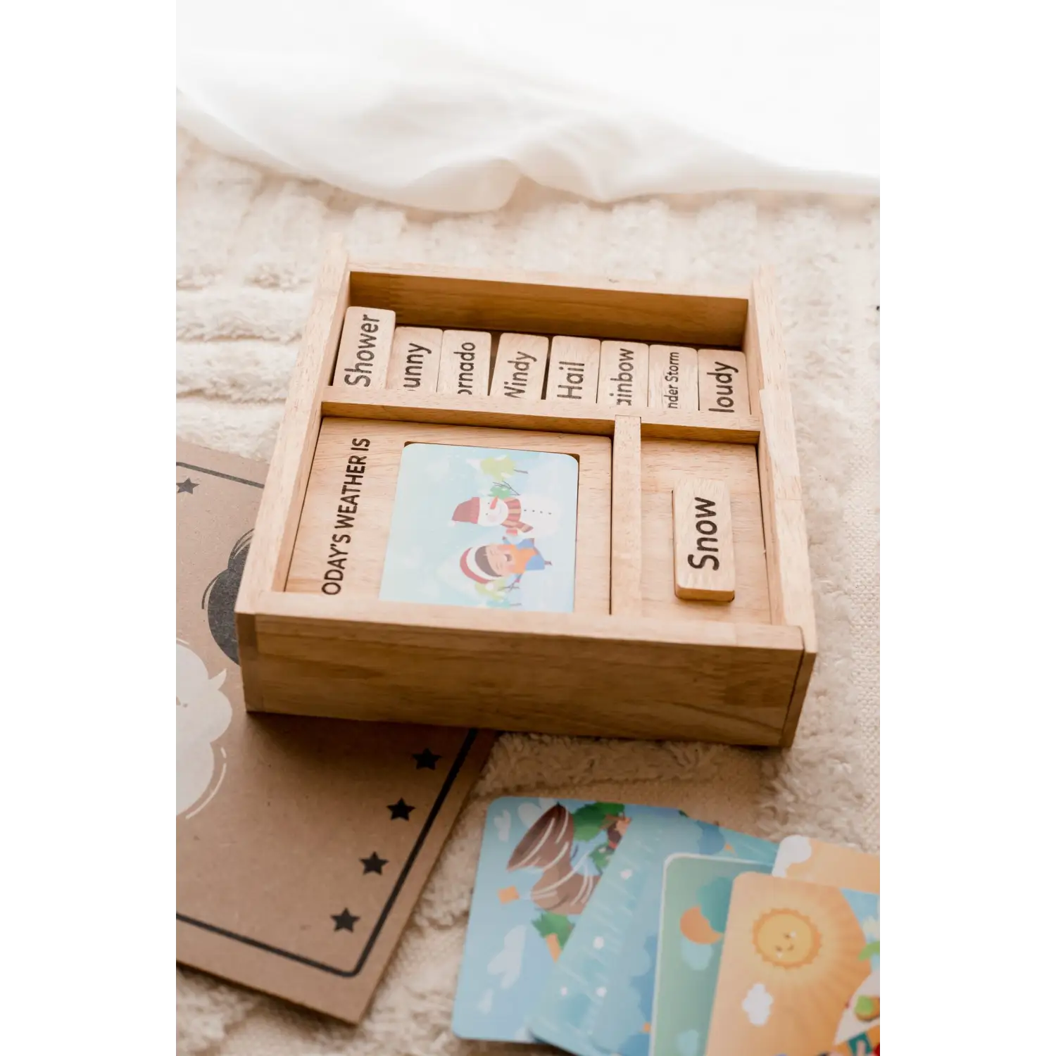 Wooden box containing cards or tiles with words and illustrations.