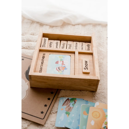 Wooden box containing cards or tiles with words and illustrations.
