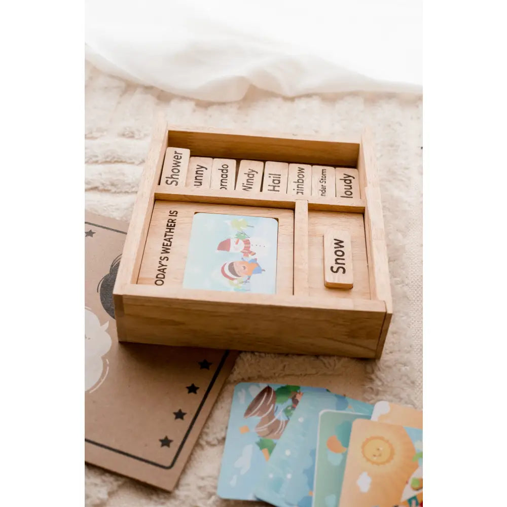 Wooden box containing cards or tiles with words and illustrations.