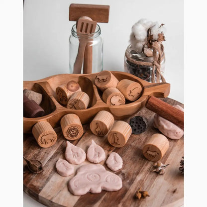 Collection of wooden stamps and clay impressions on a wooden surface.