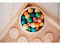 Bowl filled with colorful round candies or gumballs.
