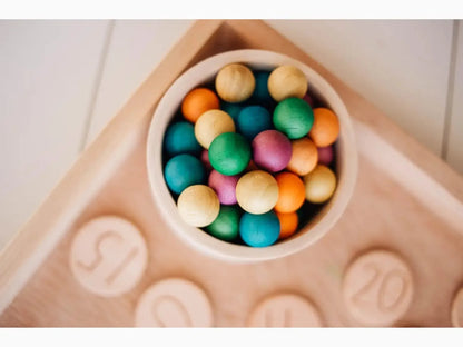 Bowl filled with colorful round candies or gumballs.