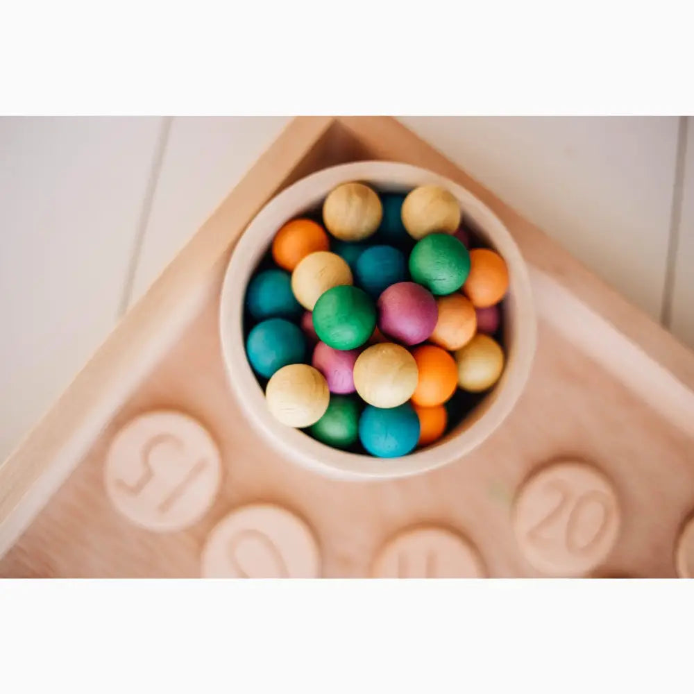 Bowl filled with colorful round candies or gumballs.