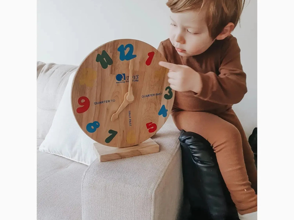 Wooden learning clock with colorful numbers.