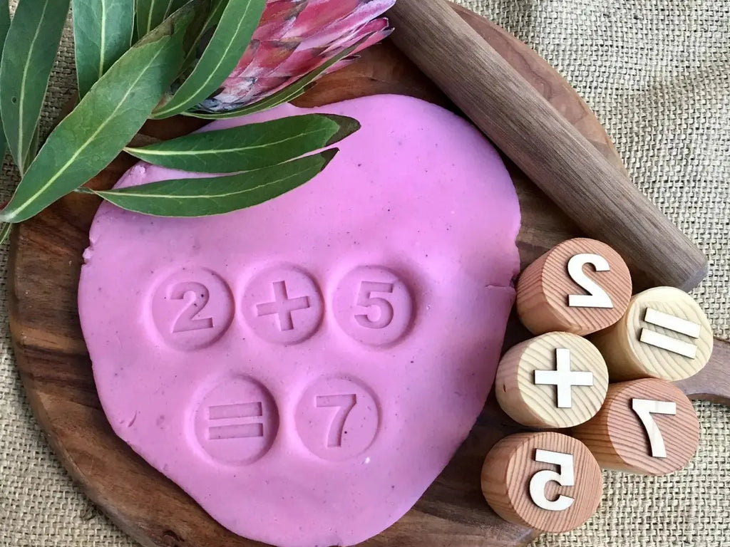 Pink heart-shaped playdough or clay with numbers imprinted on it.