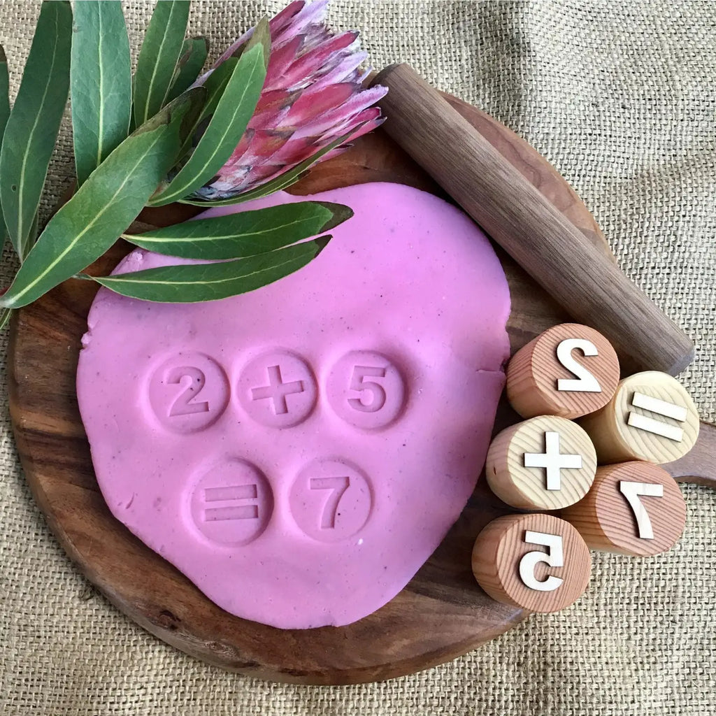 Pink heart-shaped playdough or clay with numbers imprinted on it.