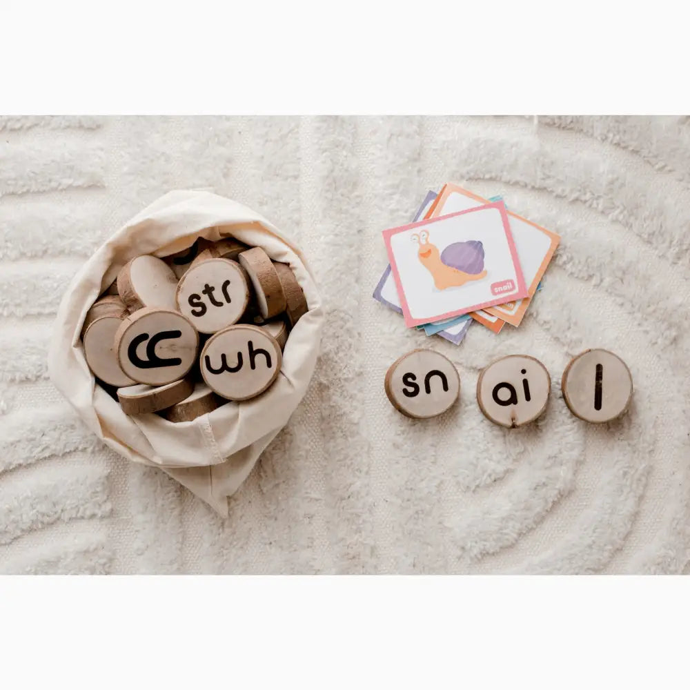 Wooden discs with letters and phonetic sounds printed on them, some in a cloth bag and others arranged separately.