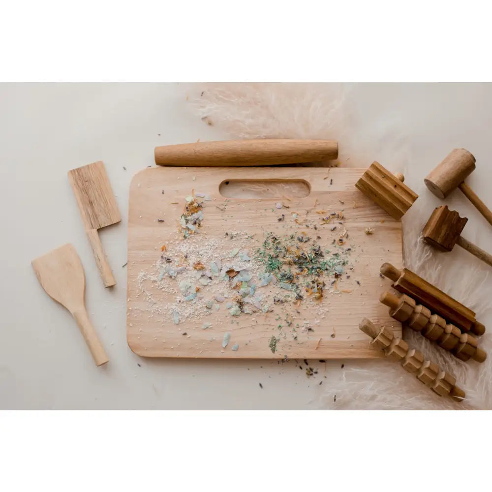 Wooden cutting board with herb or spice remnants scattered on its surface.