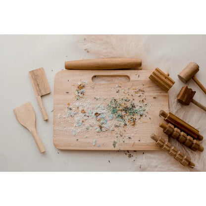 Wooden cutting board with herb or spice remnants scattered on its surface.