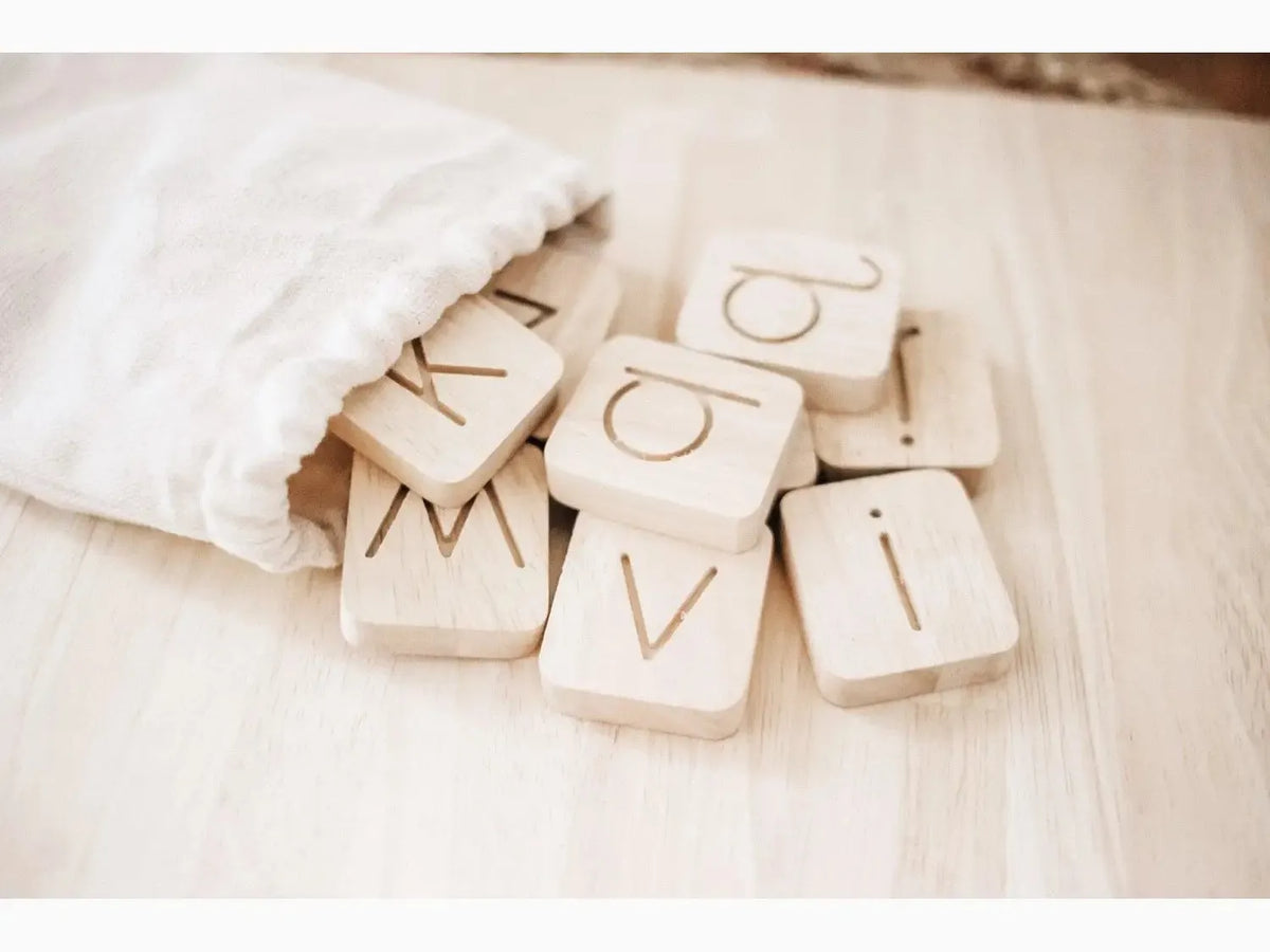Wooden letter tiles spilling out of a fabric bag.