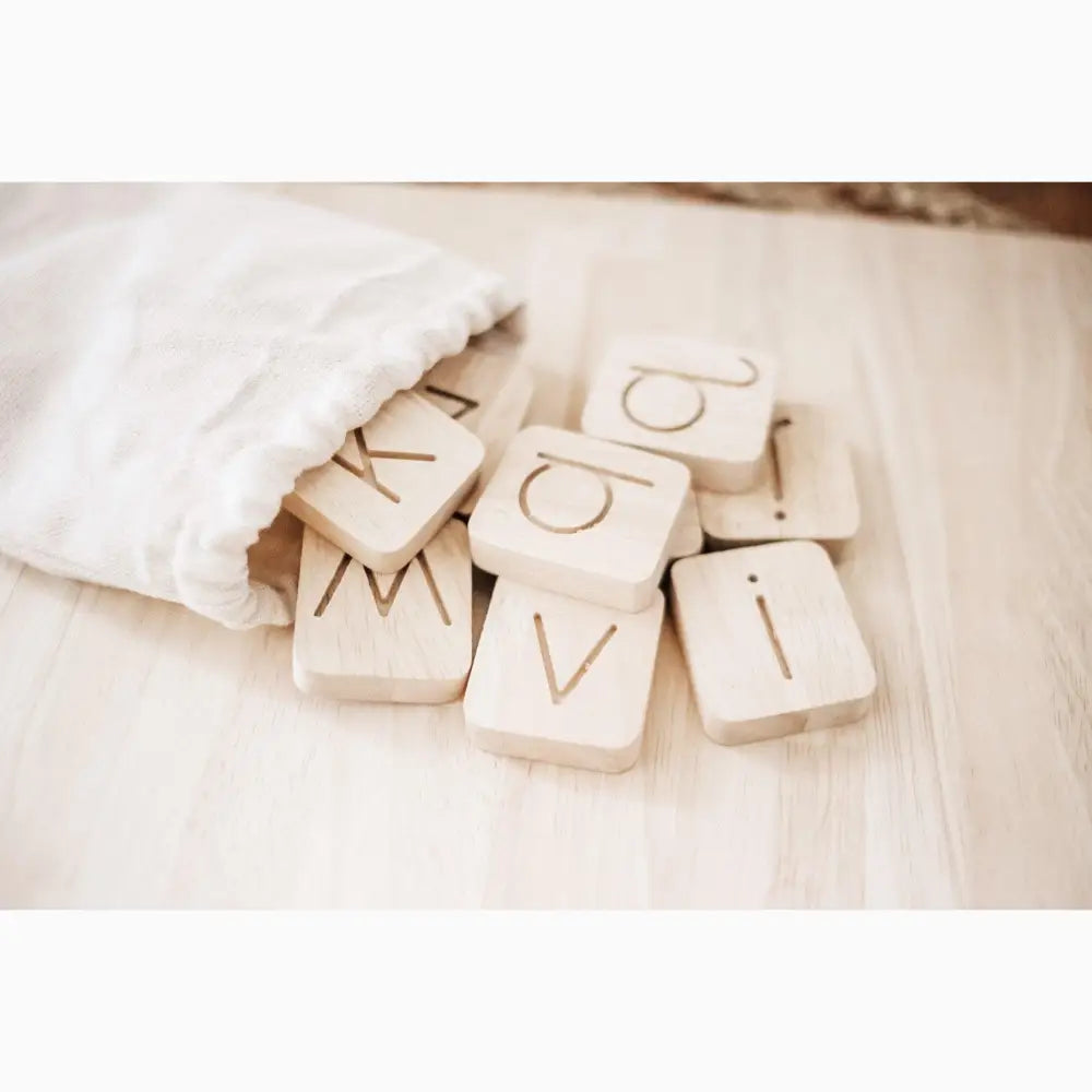 Wooden letter tiles spilling out of a fabric bag.