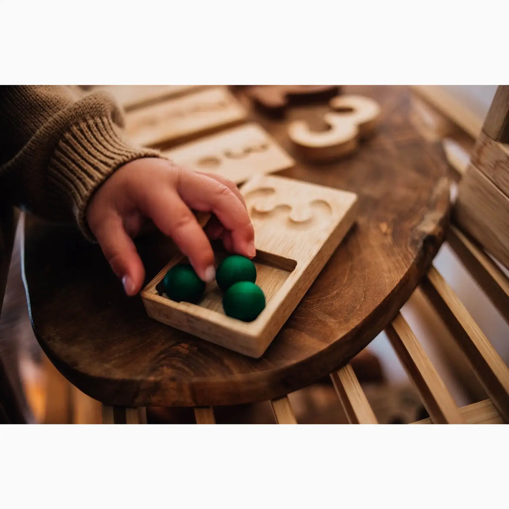 Wooden number puzzle with green balls.